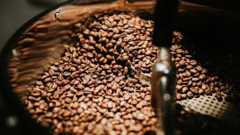 A coffee grinder processes whole coffee beans, transforming them into a fine grind for brewing.